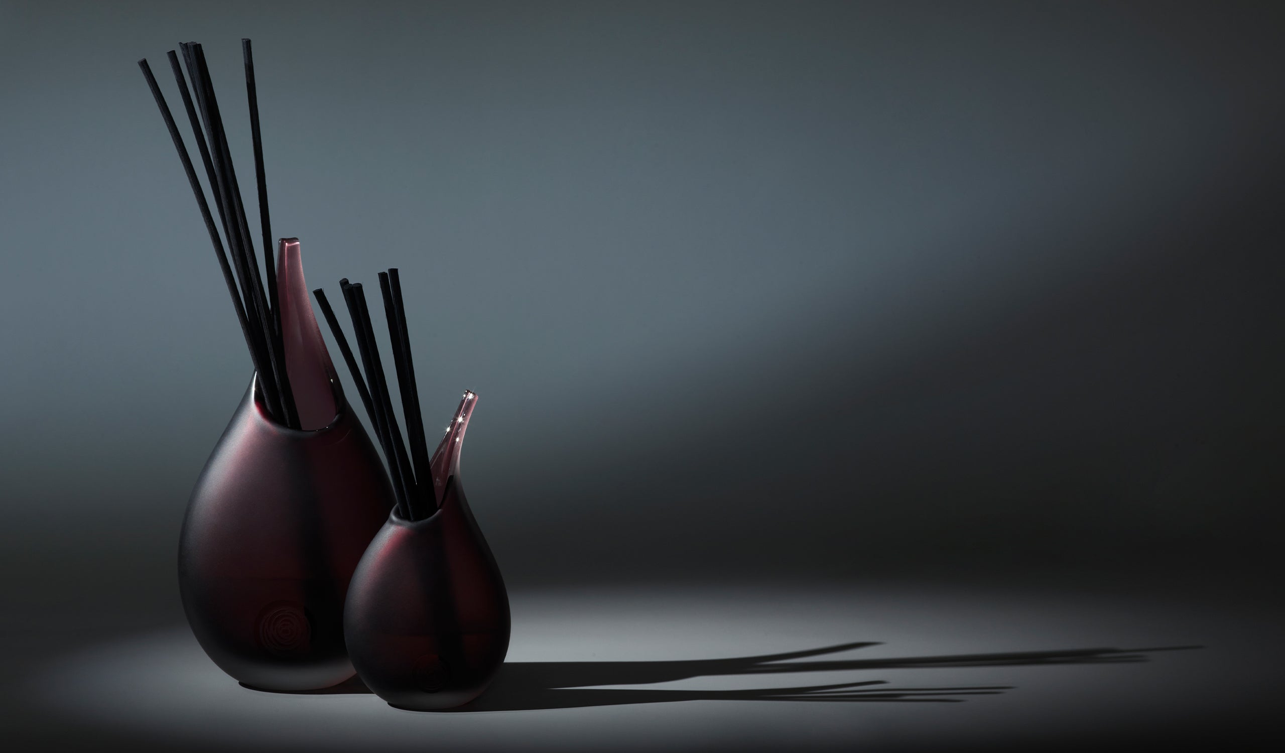 Image of Senti duo reed diffusers in Claret against a dark background